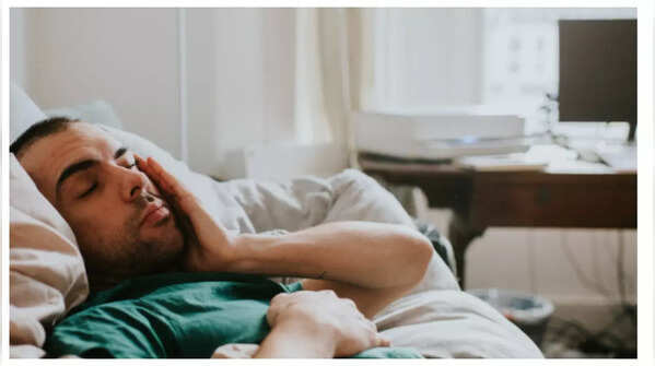 Person feeling fatigued, a subtle sign of colon cancer